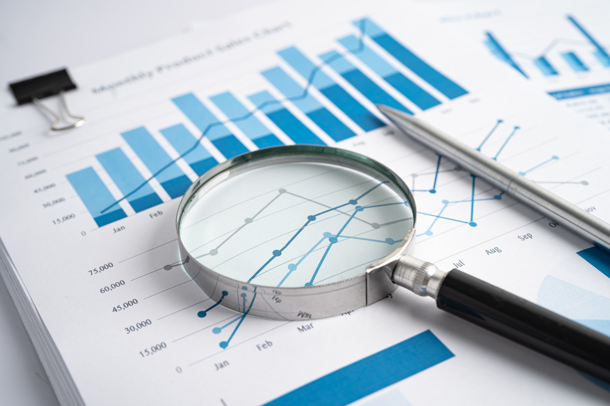 Magnifying glass on chart graph for analysis account business trade.