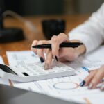 Woman accountant using calculator and computer in office panoramic banner, finance and accounting