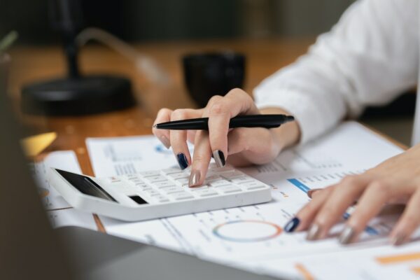 Woman accountant using calculator and computer in office panoramic banner, finance and accounting