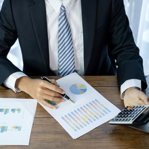 Young businessman financial market analyst sits at their desks and calculate financial graphs